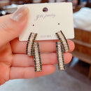 Novos brincos curvos com diamantes na frente e nas costas
